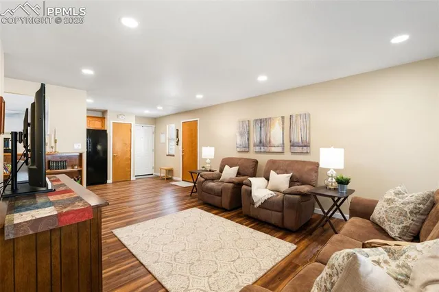 a living room with furniture and a wooden floor