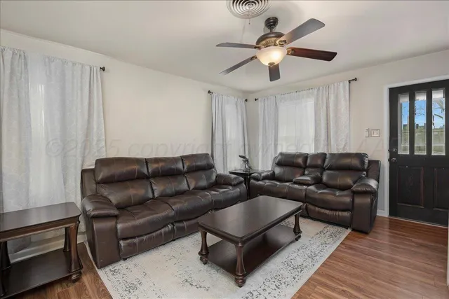 a living room with furniture a ceiling fan and a rug