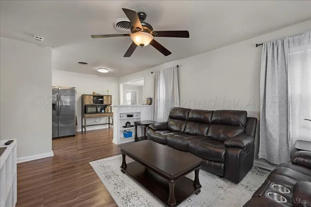 a living room with furniture and a wooden floor