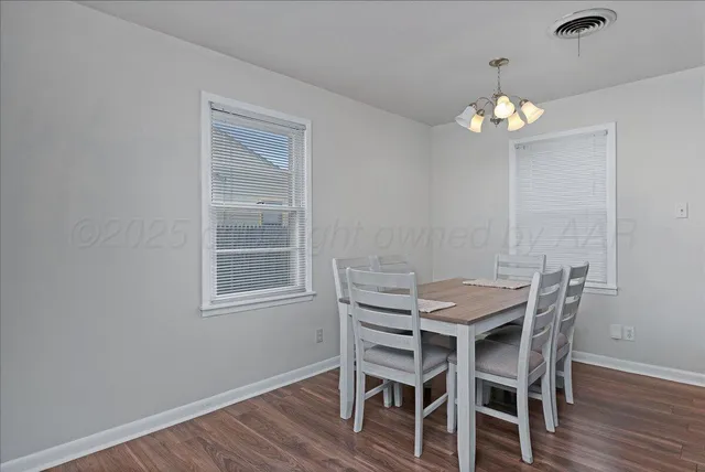a view of a dining room with furniture wooden floor and chandelier