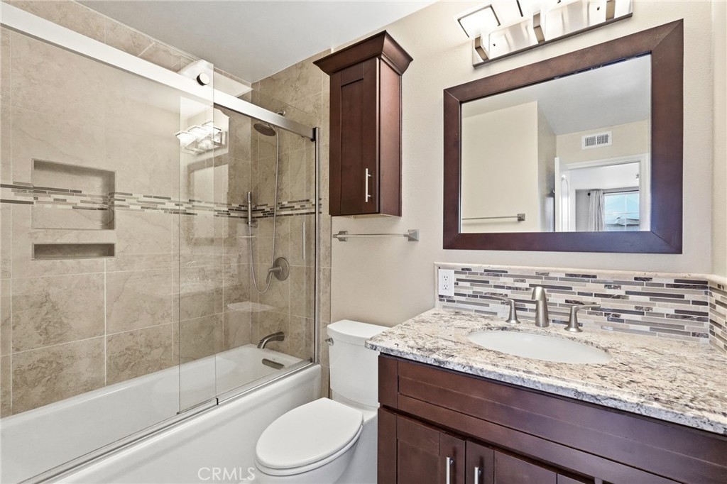 19208 Hamlin Street, Unit 5 Reseda, CA 91335 - Photo 14 of 31 a bathroom with a granite countertop sink a toilet and shower