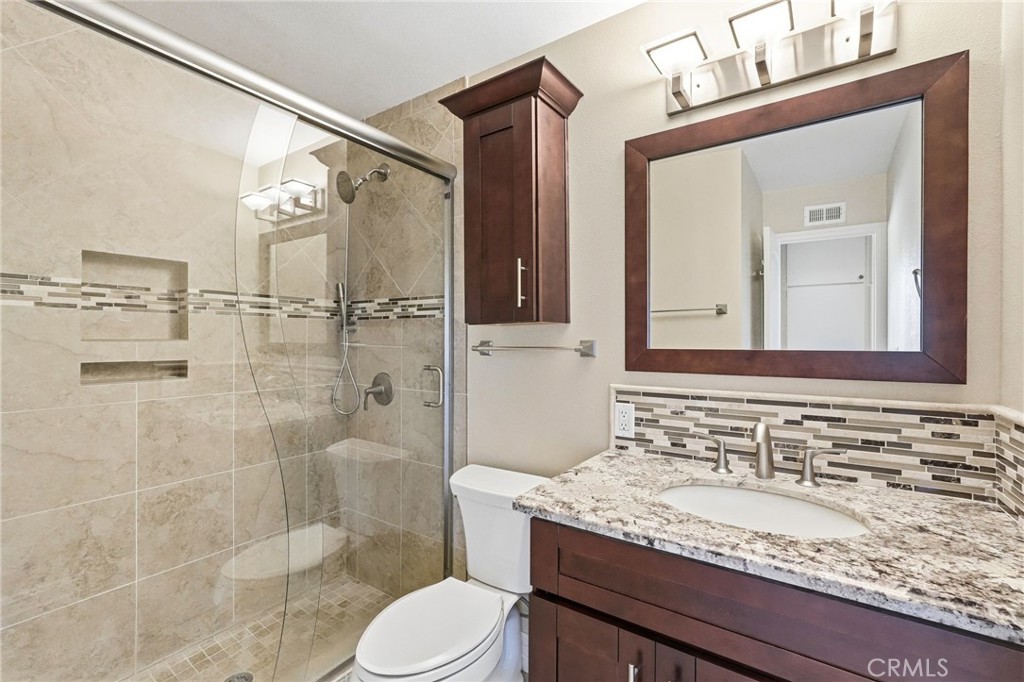 19208 Hamlin Street, Unit 5 Reseda, CA 91335 - Photo 20 of 31 a bathroom with a granite countertop sink toilet a mirror and shower