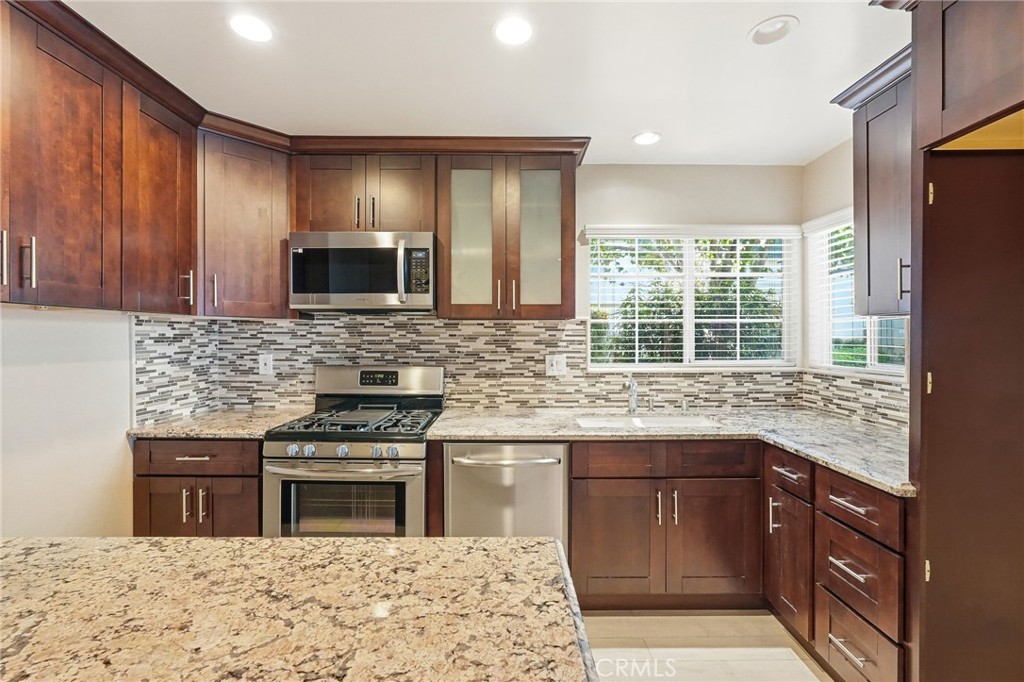 19208 Hamlin Street, Unit 5 Reseda, CA 91335 - Photo 10 of 31 a kitchen with stainless steel appliances granite countertop wooden cabinets granite counter tops and a window