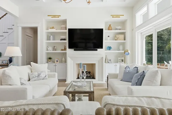 a hallway with white doors wooden floor and stairs