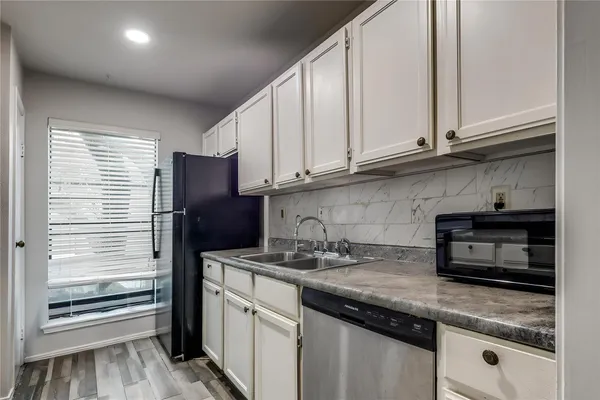 a kitchen with stainless steel appliances granite countertop a refrigerator sink and microwave
