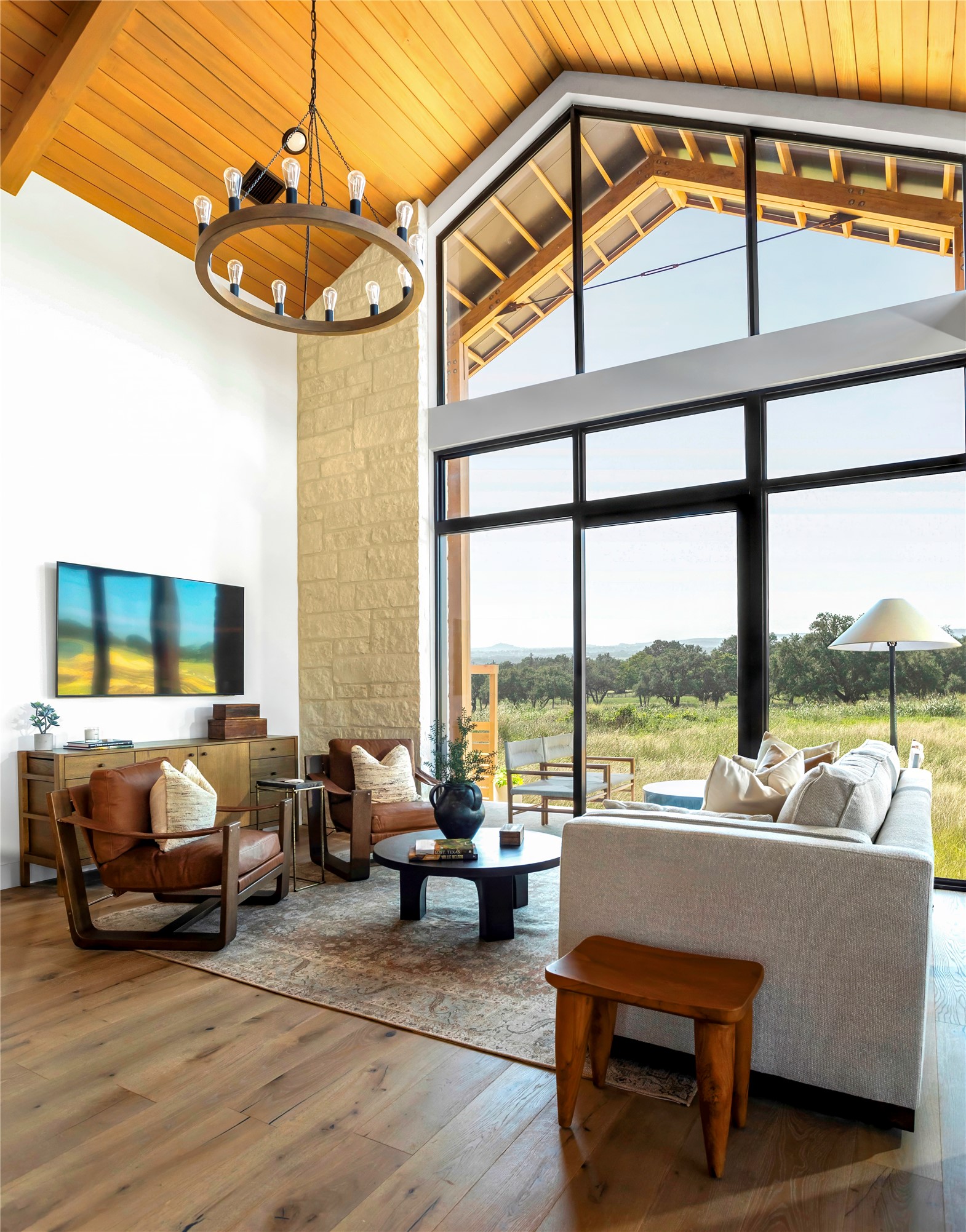 310 Hye Springs Road, Unit 107 Hye, TX 78635 - Photo 16 of 20 Dramatic floor-to-ceiling windows and vaulted wood ceilings create a bright, inviting living area with seamless indoor-outdoor connection.