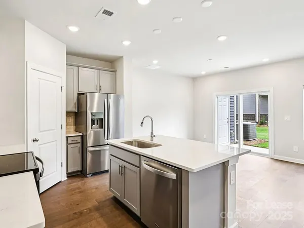 a kitchen that has a refrigerator a sink and a stove
