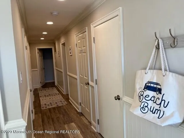 a view of a hallway with wooden floor and a bathroom