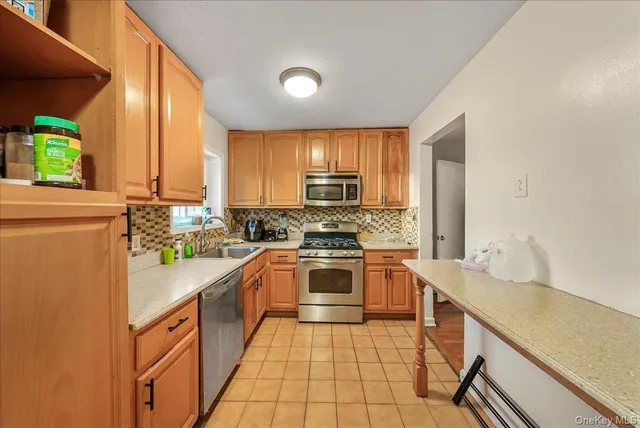 a kitchen with stainless steel appliances granite countertop a sink counter space cabinets and a large window