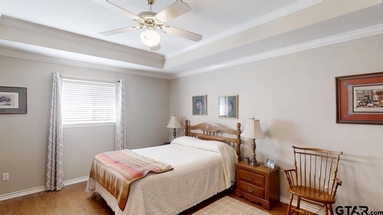 1202 Rice Road, Unit 143 Tyler, TX 75703 - Photo 14 of 27 a bedroom with a bed and a chandelier