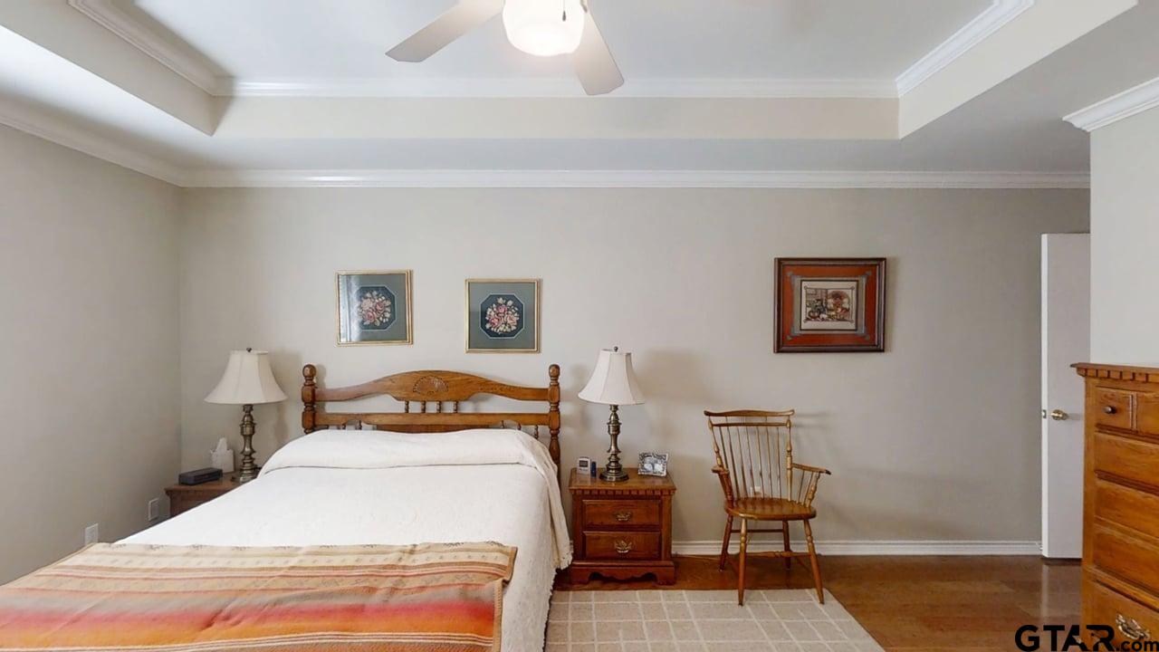 1202 Rice Road, Unit 143 Tyler, TX 75703 - Photo 15 of 27 a bedroom with a bed and wooden floor