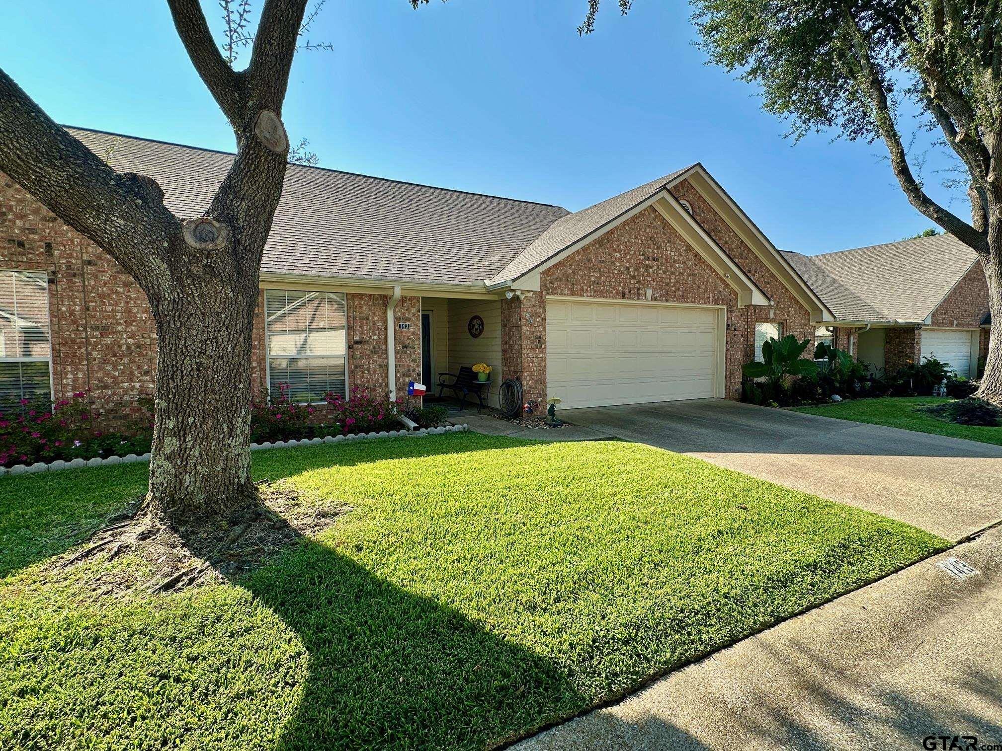 1202 Rice Road, Unit 143 Tyler, TX 75703 - Photo 2 of 27 a front view of a house with garden