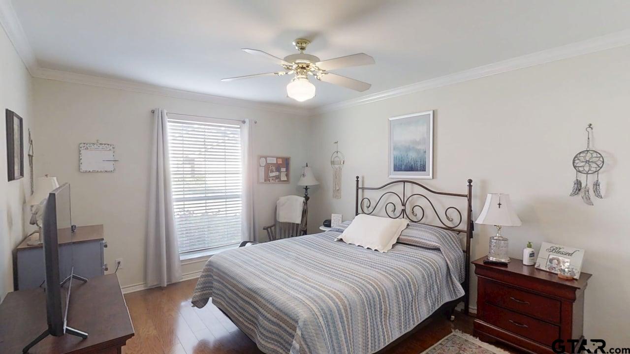 1202 Rice Road, Unit 143 Tyler, TX 75703 - Photo 22 of 27 a bedroom with a bed and a chandelier