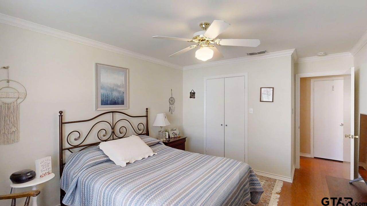 1202 Rice Road, Unit 143 Tyler, TX 75703 - Photo 23 of 27 a bedroom with a bed and a chandelier