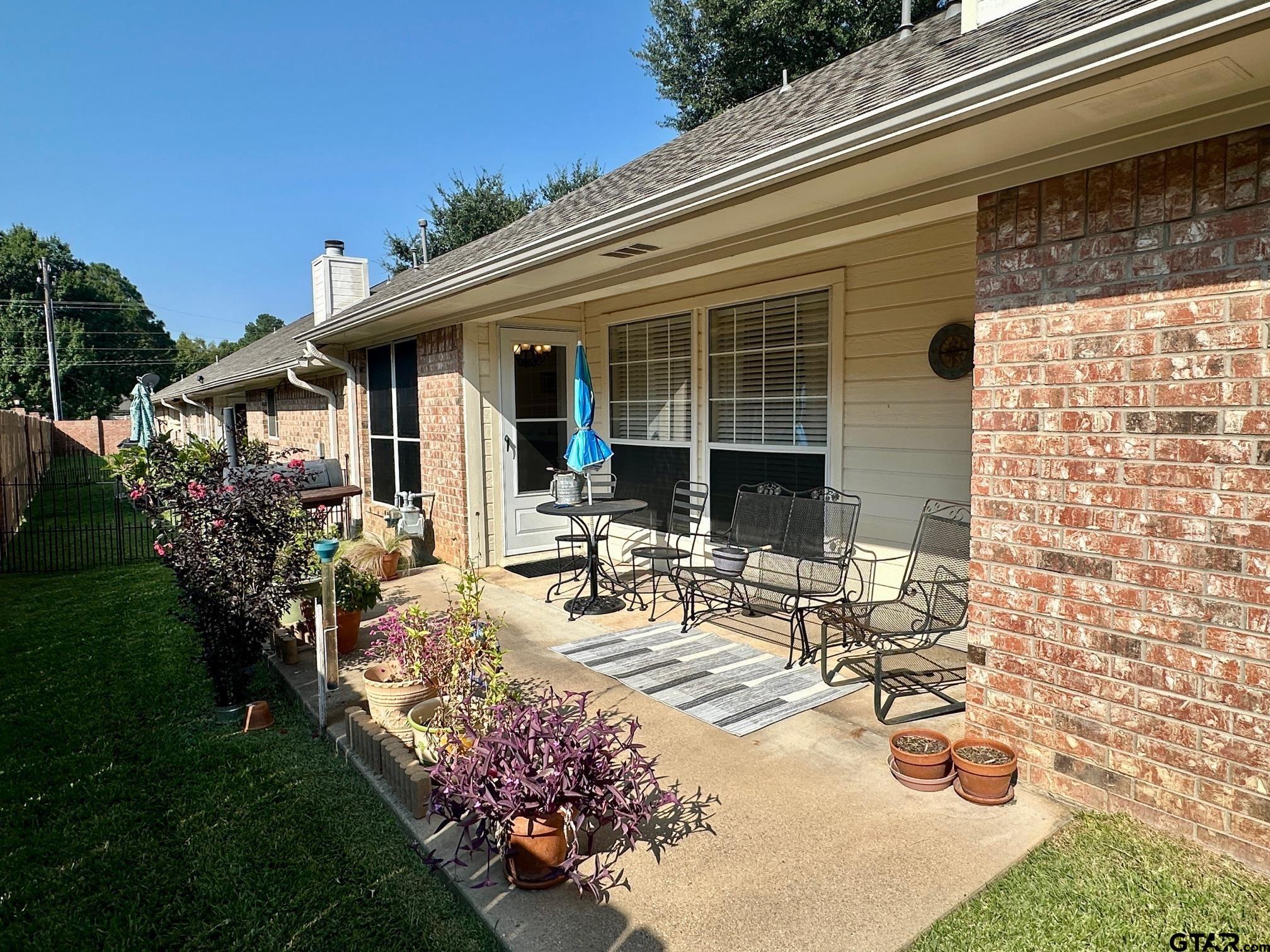 1202 Rice Road, Unit 143 Tyler, TX 75703 - Photo 25 of 27 a view of a house with backyard sitting area and garden