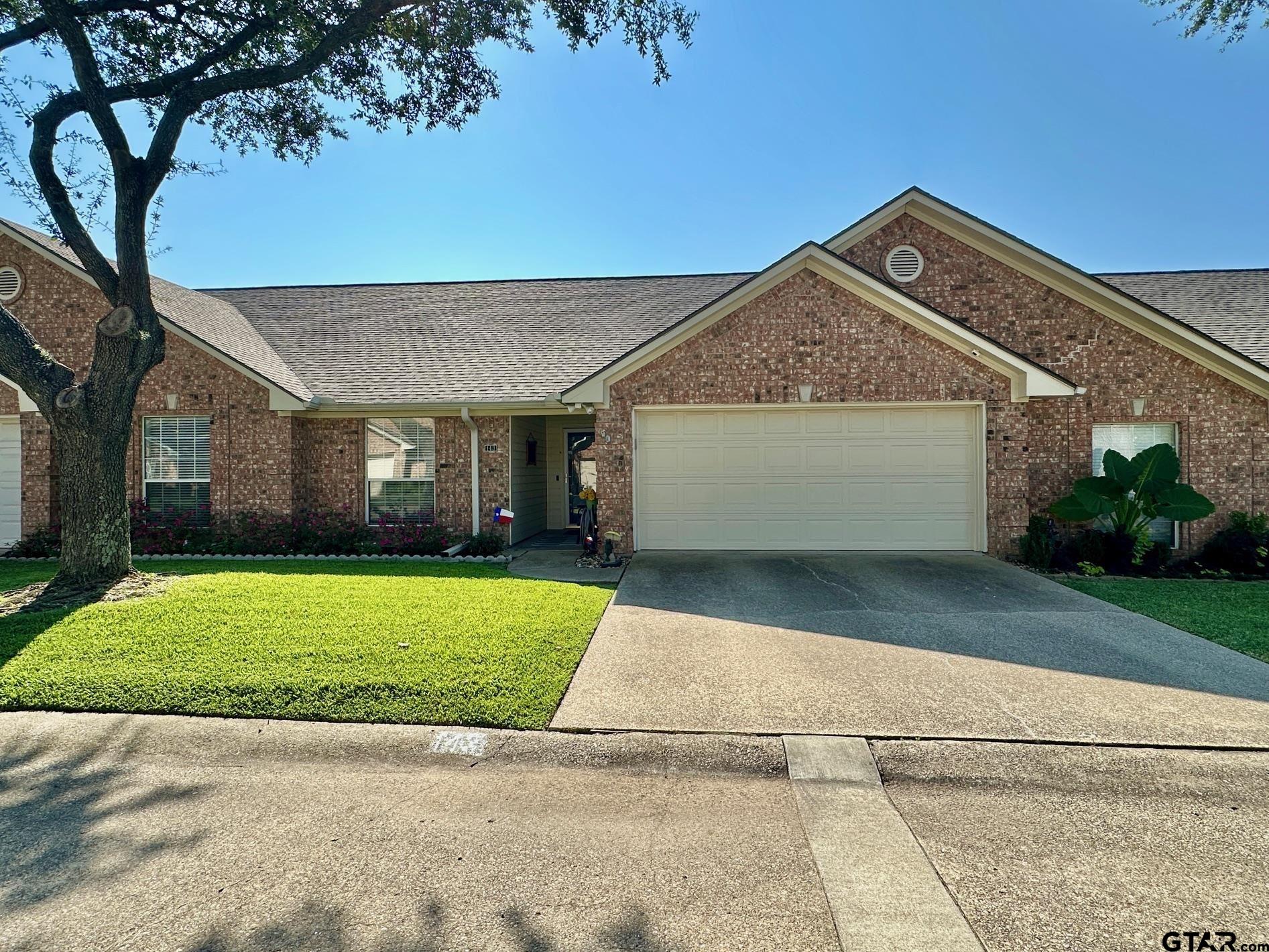 1202 Rice Road, Unit 143 Tyler, TX 75703 - Photo 3 of 27 a front view of a house with a garden