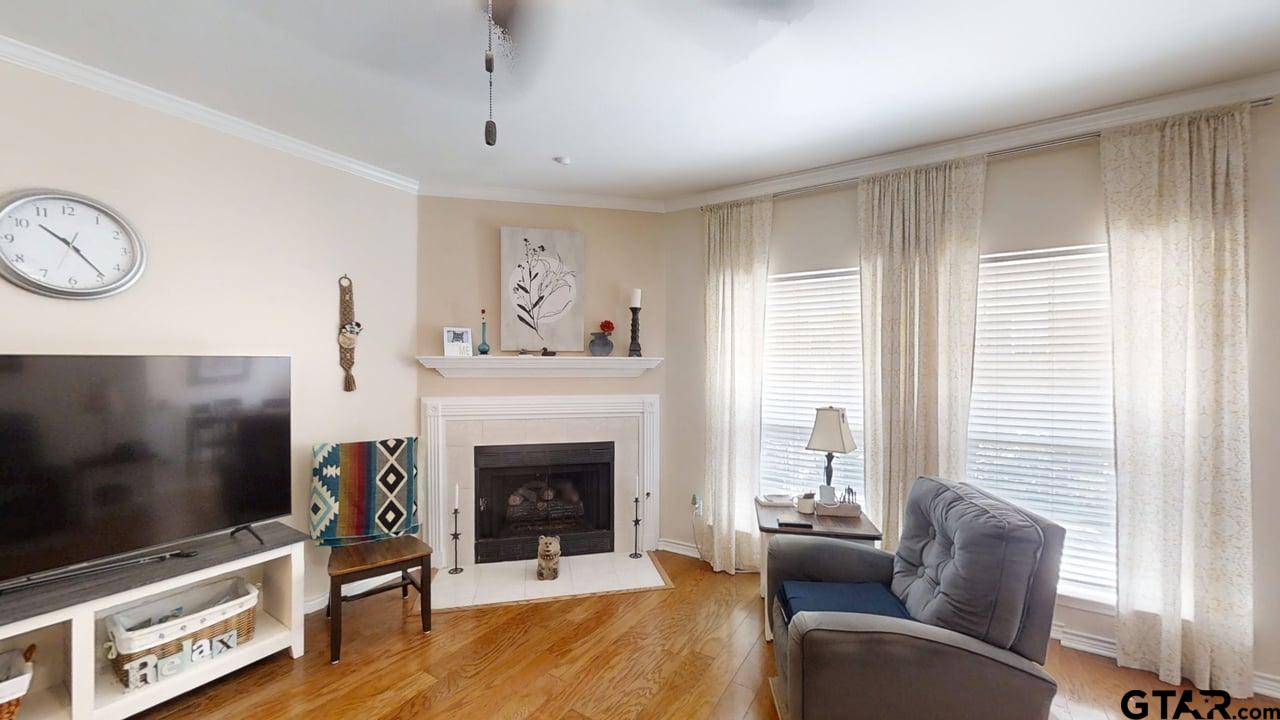 1202 Rice Road, Unit 143 Tyler, TX 75703 - Photo 6 of 27 a living room with furniture a flat screen tv and a fireplace