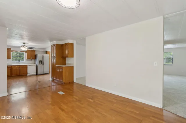 an empty room with windows and fan