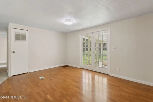 an empty room with windows and fan