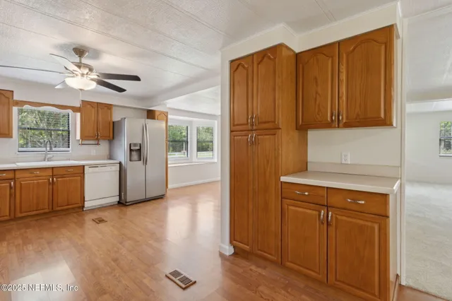an empty room with windows and ceiling fan