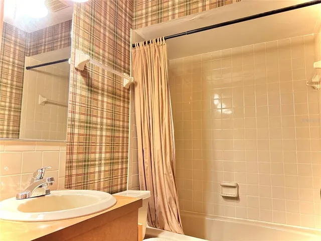 a living room with furniture a flat screen tv and a refrigerator