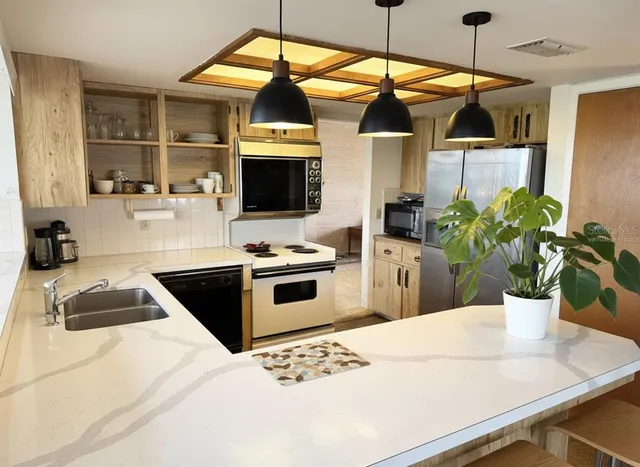 a bedroom with a bed table flowerpot and window