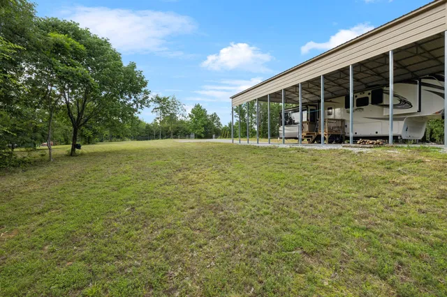 a view of an house with backyard space and balcony