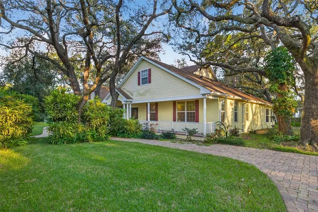 a front view of a house with a yard and trees