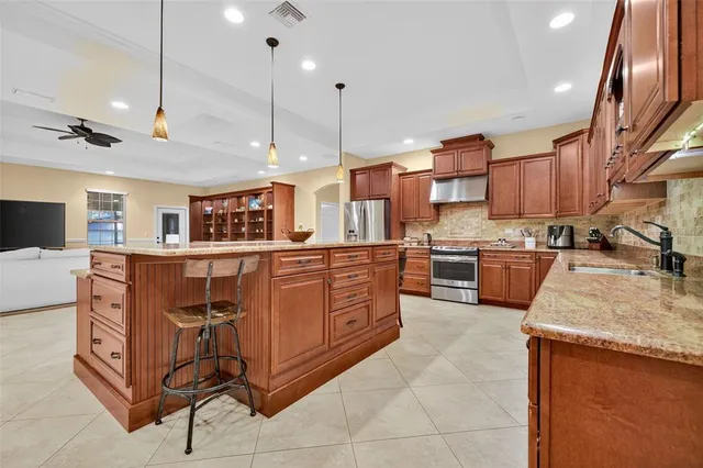 a large kitchen with stainless steel appliances granite countertop a stove and a sink