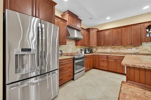 a kitchen with stainless steel appliances granite countertop a refrigerator sink and cabinets
