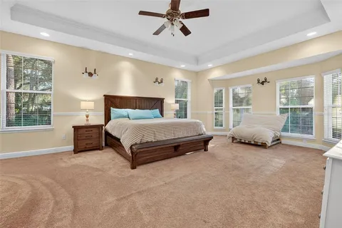 a spacious bedroom with a bed couch and window