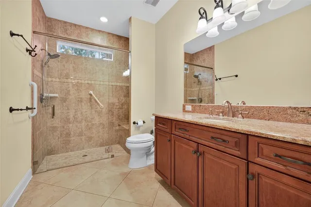 a bathroom with a granite countertop sink toilet and shower