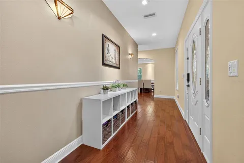 a view of a hallway with wooden floor and furniture