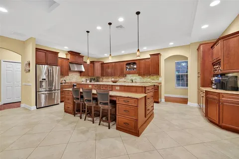 a kitchen with kitchen island granite countertop a sink counter top space appliances and cabinets