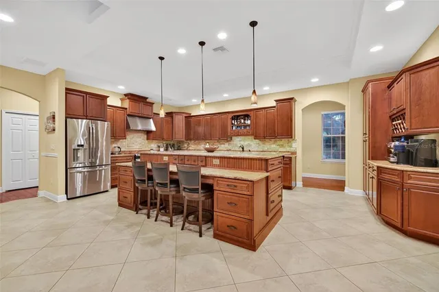 a kitchen with kitchen island granite countertop a sink counter top space appliances and cabinets