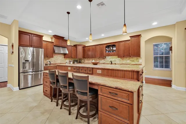 a kitchen with kitchen island a counter top space appliances and cabinets