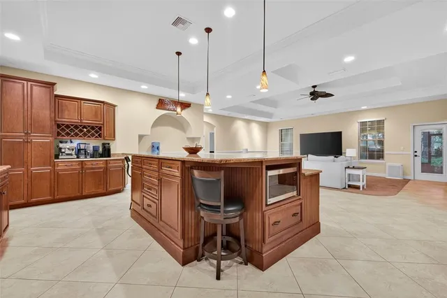 a kitchen with kitchen island a counter top space appliances and a cabinets