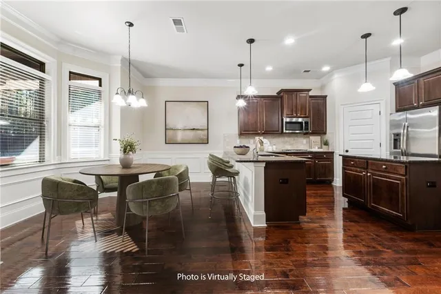 a kitchen with stainless steel appliances granite countertop a refrigerator a sink a stove and oven