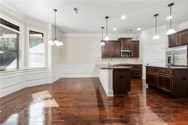 a kitchen with stainless steel appliances granite countertop a sink a stove microwave and refrigerator