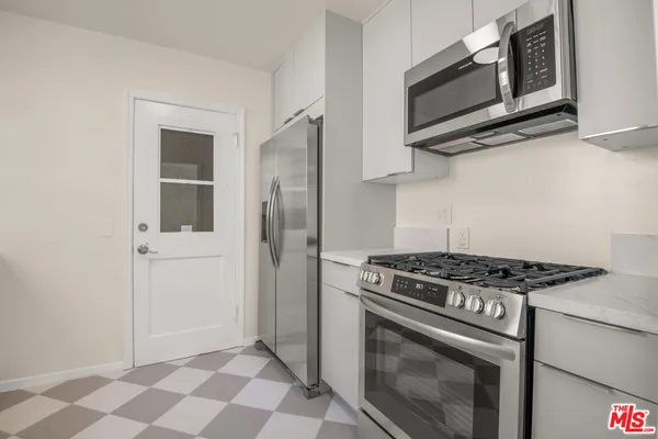 a kitchen with stainless steel appliances granite countertop white cabinets and black stove top oven
