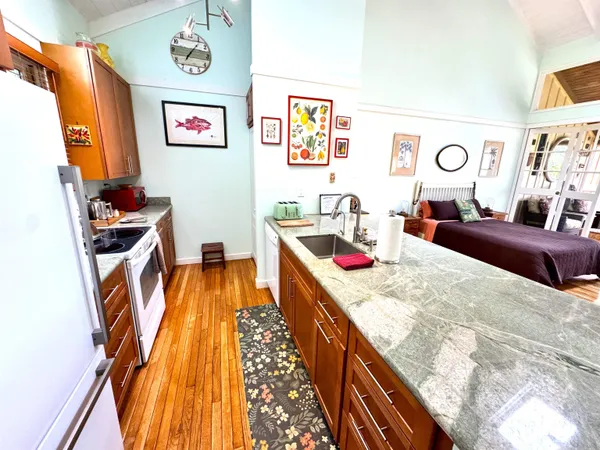 a front view of a building with lot of cars and trees