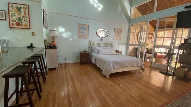 a bedroom with a bed and wooden floor