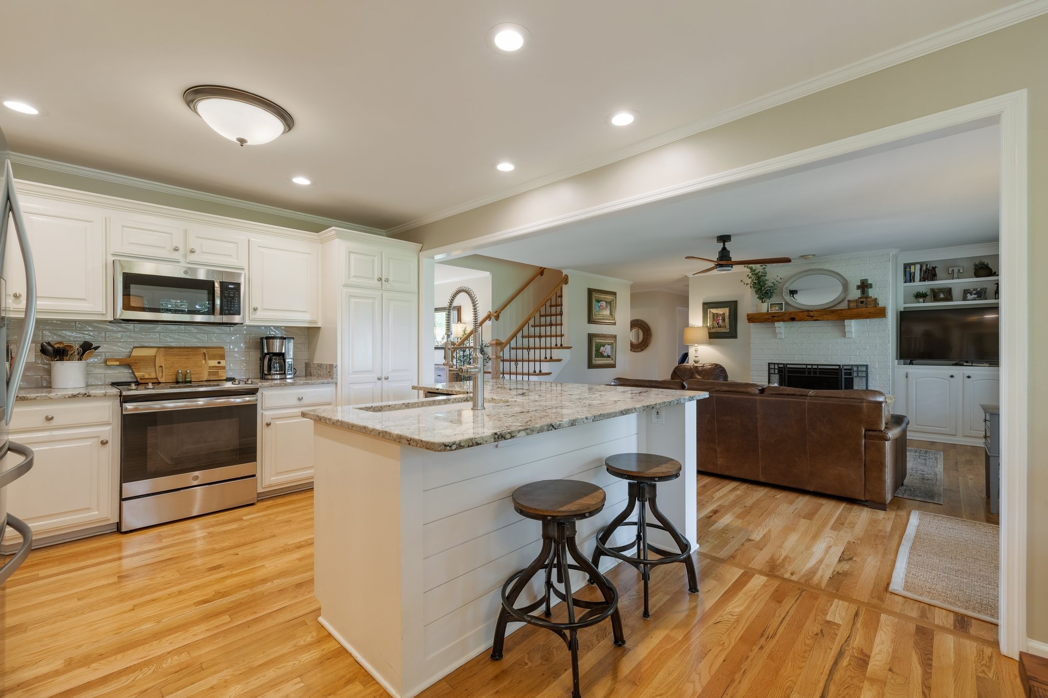 6223 Ladd Road Franklin, TN 37067 - Photo 14 of 67 a kitchen with stainless steel appliances granite countertop a stove top oven a sink dishwasher a dining table and chairs with wooden floor