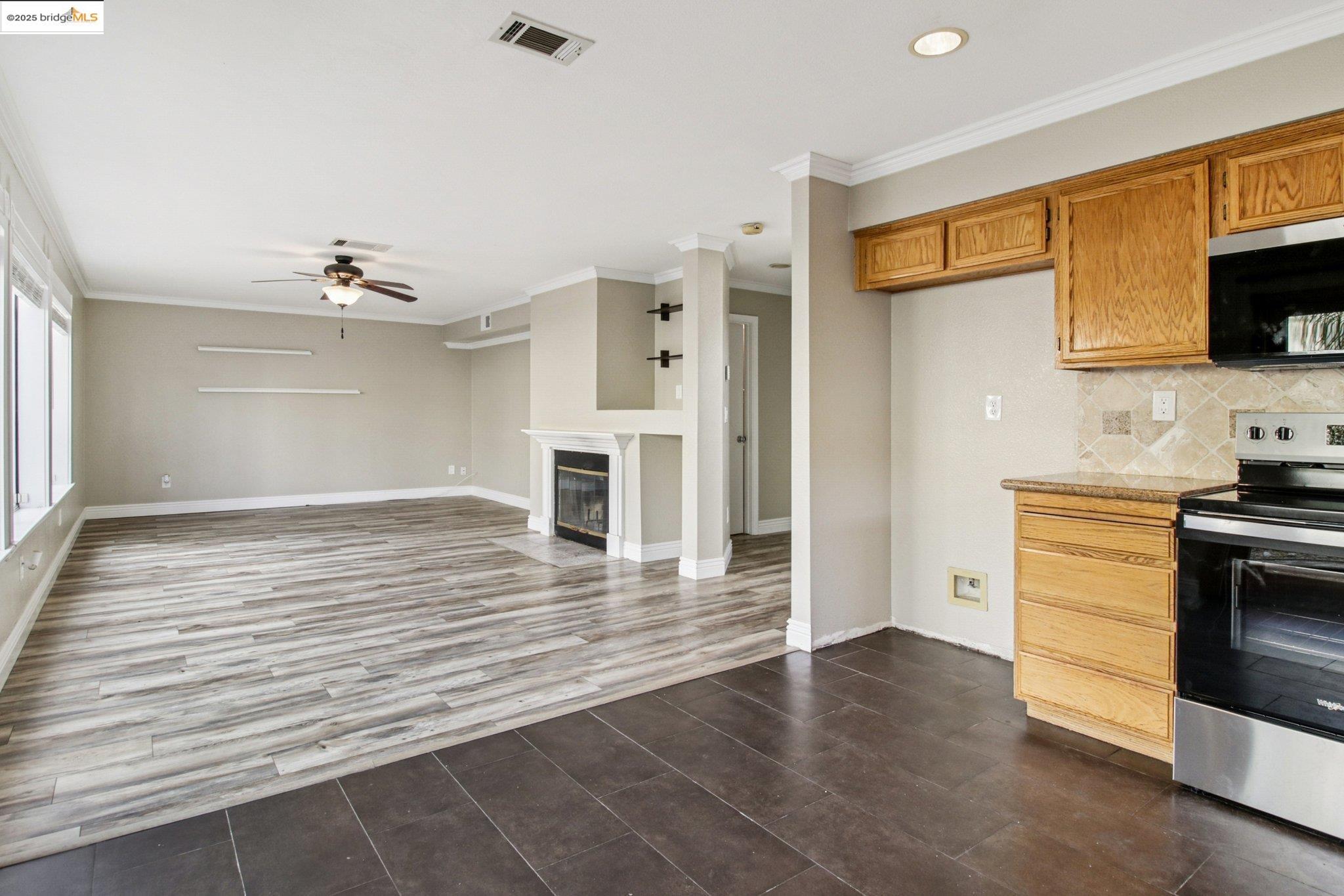 1559 Freed Circle Pittsburg, CA 94565 - Photo 14 of 32 a view of a kitchen with wooden floor and a ceiling fan