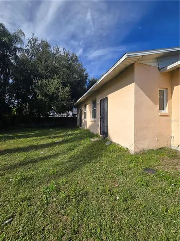 a view of a backyard with plants and large trees