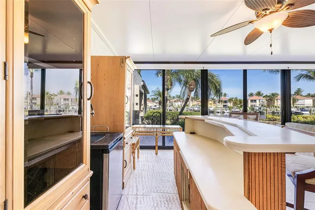 a dining hall with stainless steel appliances kitchen island granite countertop a large window and couch