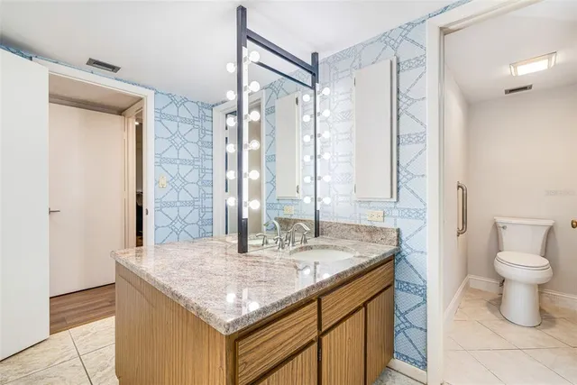 a bathroom with a granite countertop sink and a mirror