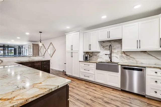 a kitchen with stainless steel appliances granite countertop a stove a sink and a refrigerator