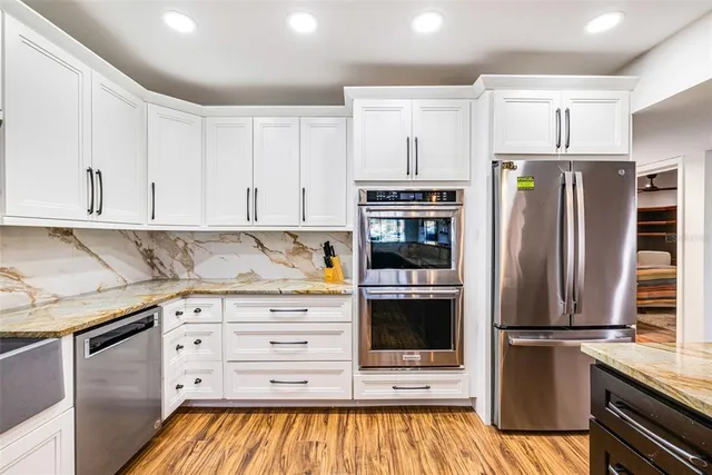 a kitchen with stainless steel appliances a refrigerator and cabinets