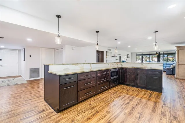 a large kitchen with stainless steel appliances kitchen island granite countertop a large island in the center